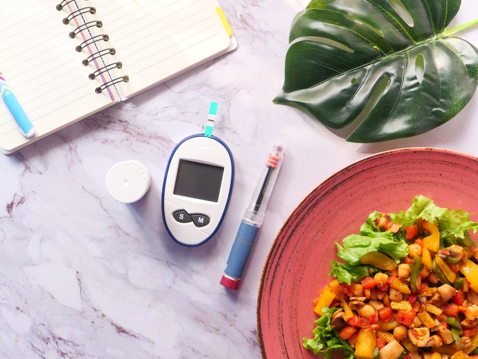 Lecteur de glycémie, injection et assiette santé illustrant la gestion du diabète de type 2 avec l’alimentation et les médicaments